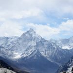 aerial photography of mountain range covered with snow under white and blue sky at daytime